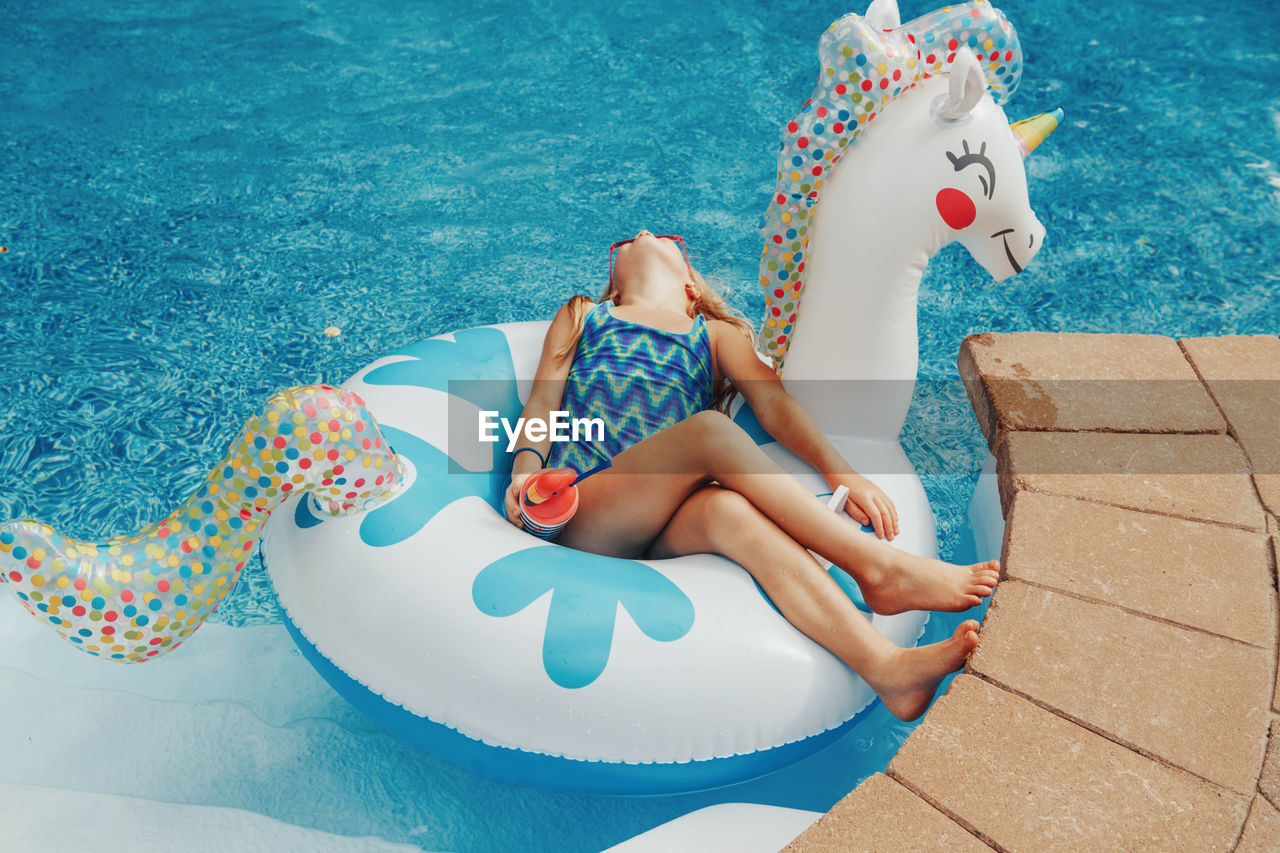 High angle view of boy sitting in swimming pool