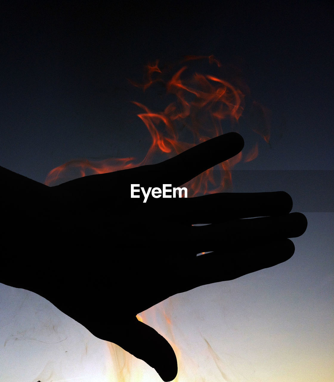 Close-up of hand against sky at night