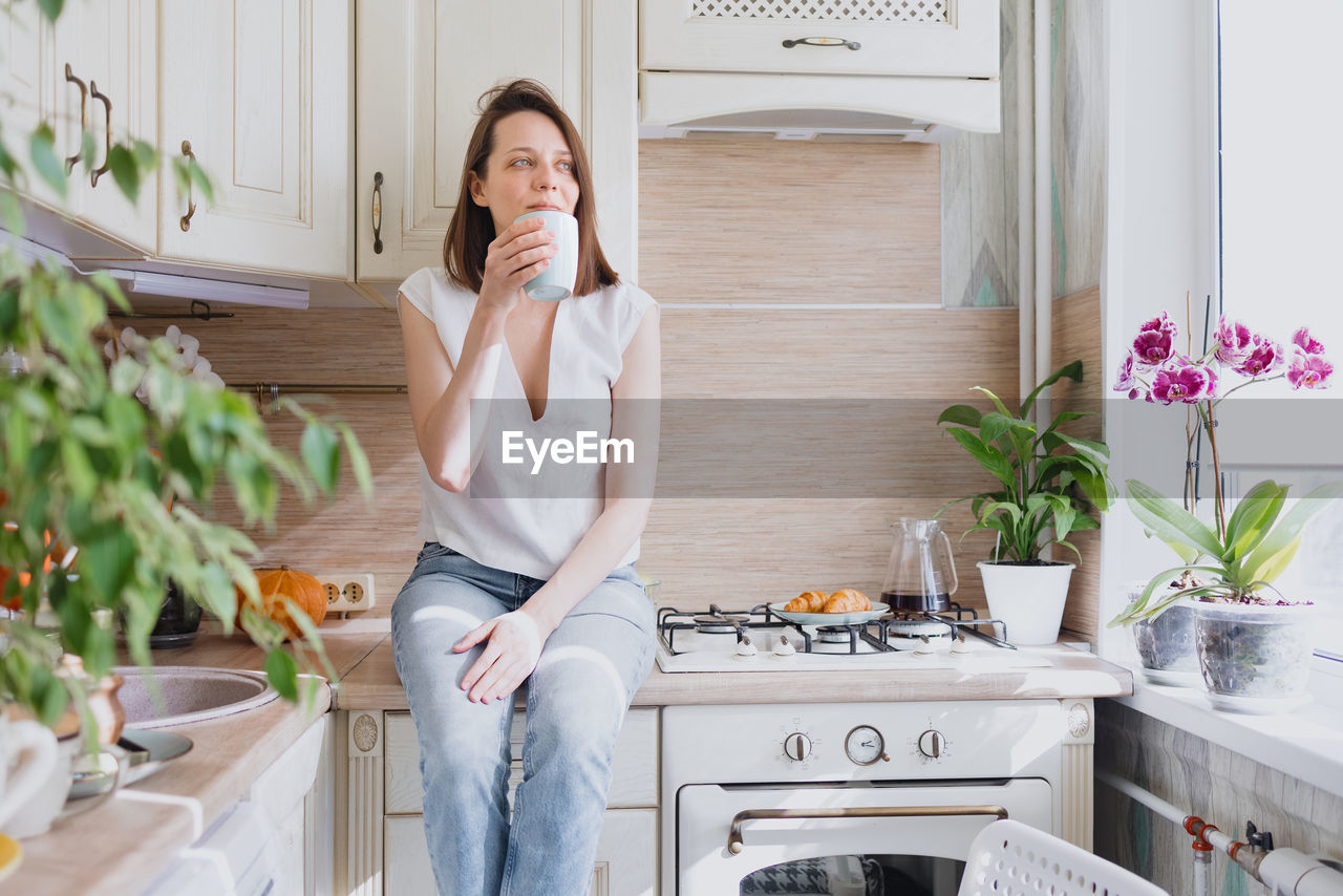 Woman with potted plants at home