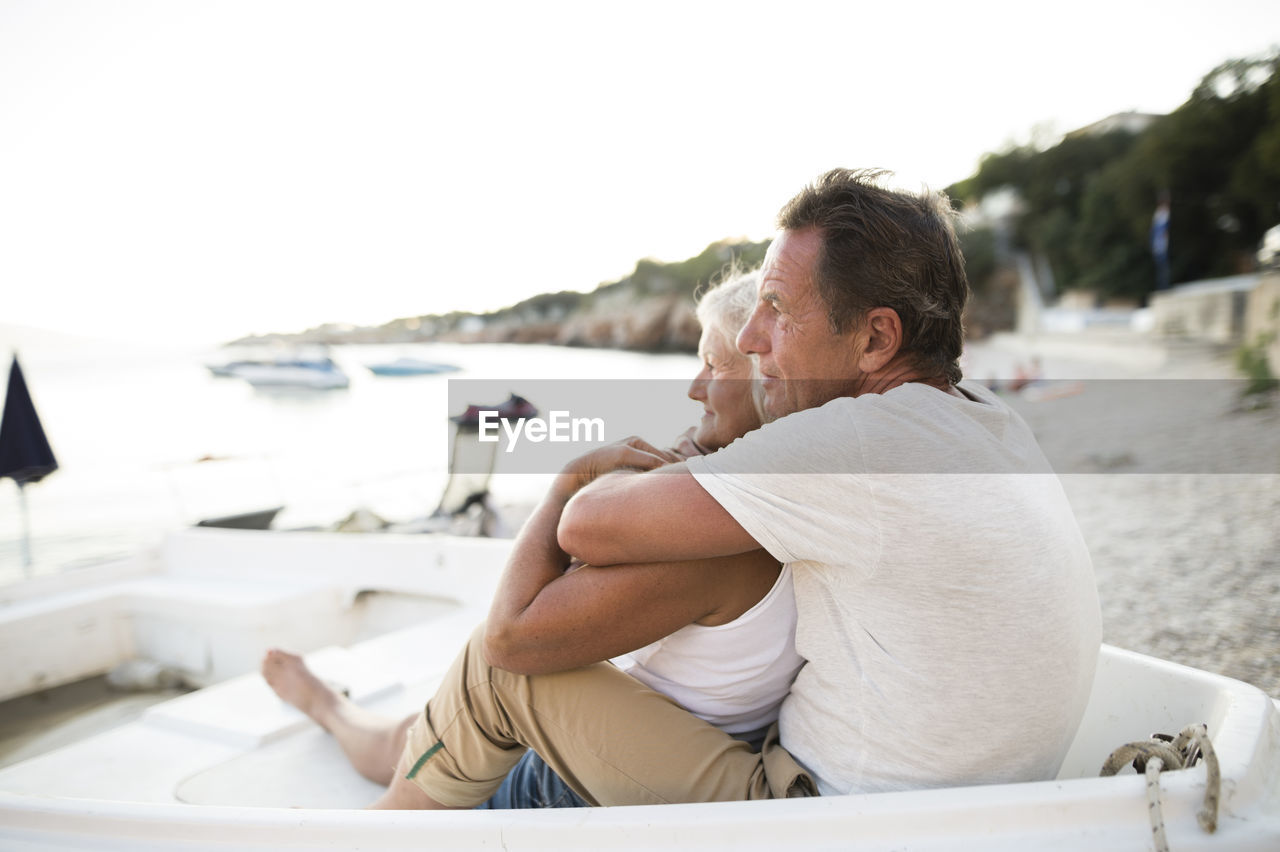 Senior couple relaxing in a boat on the beach in the evening