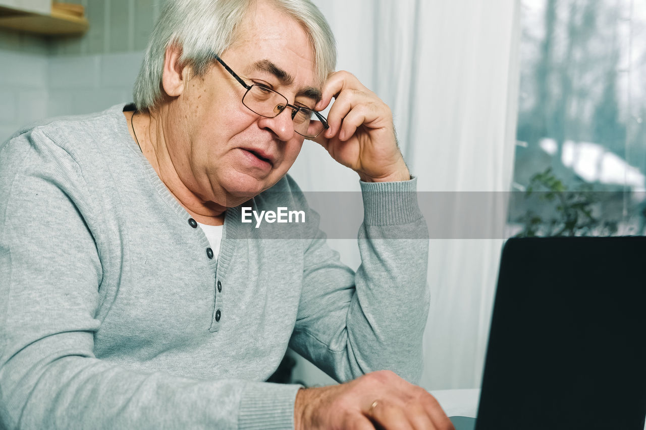 young man using laptop while sitting at home