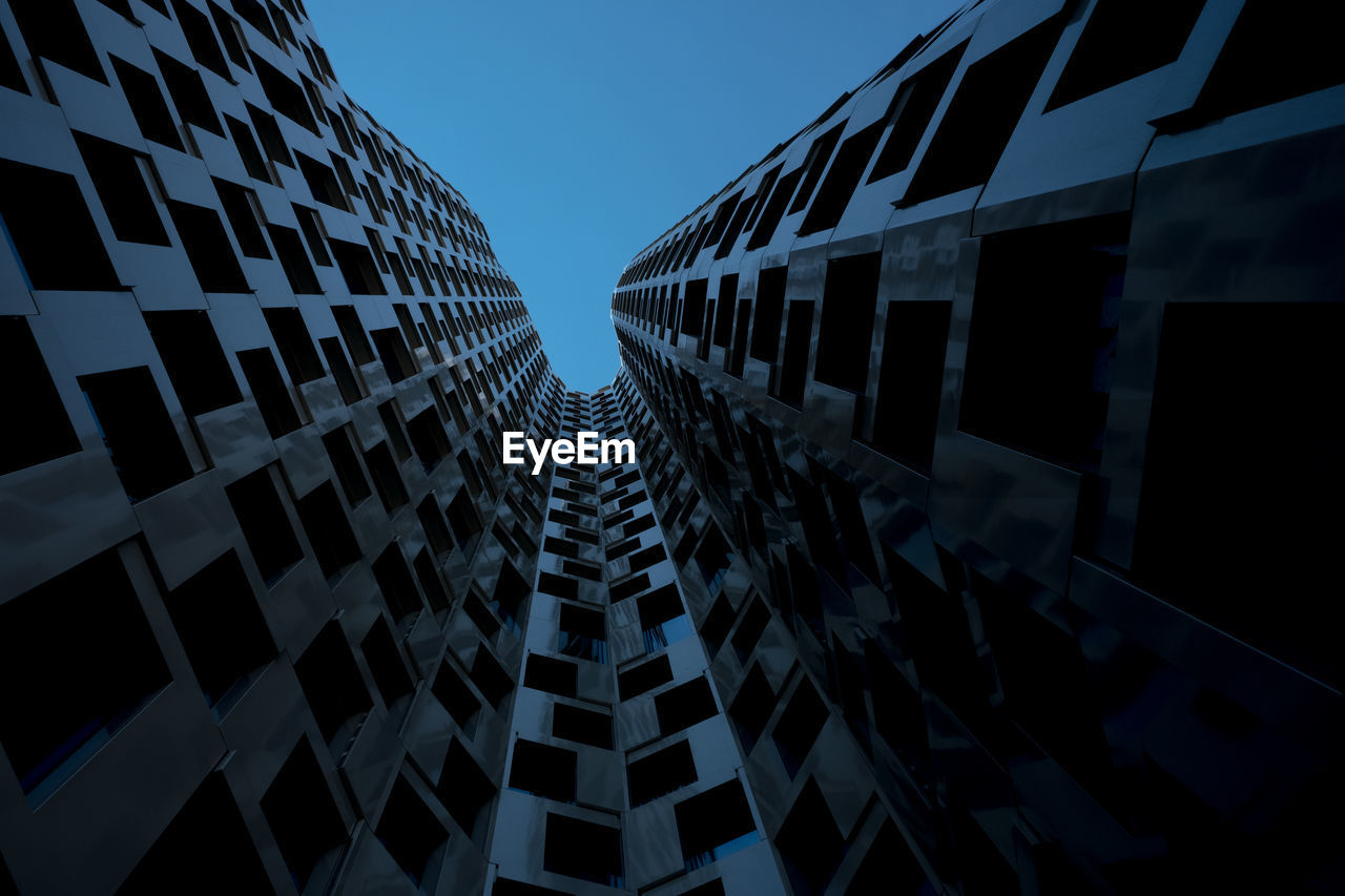 Low angle view of modern buildings against clear sky at dusk