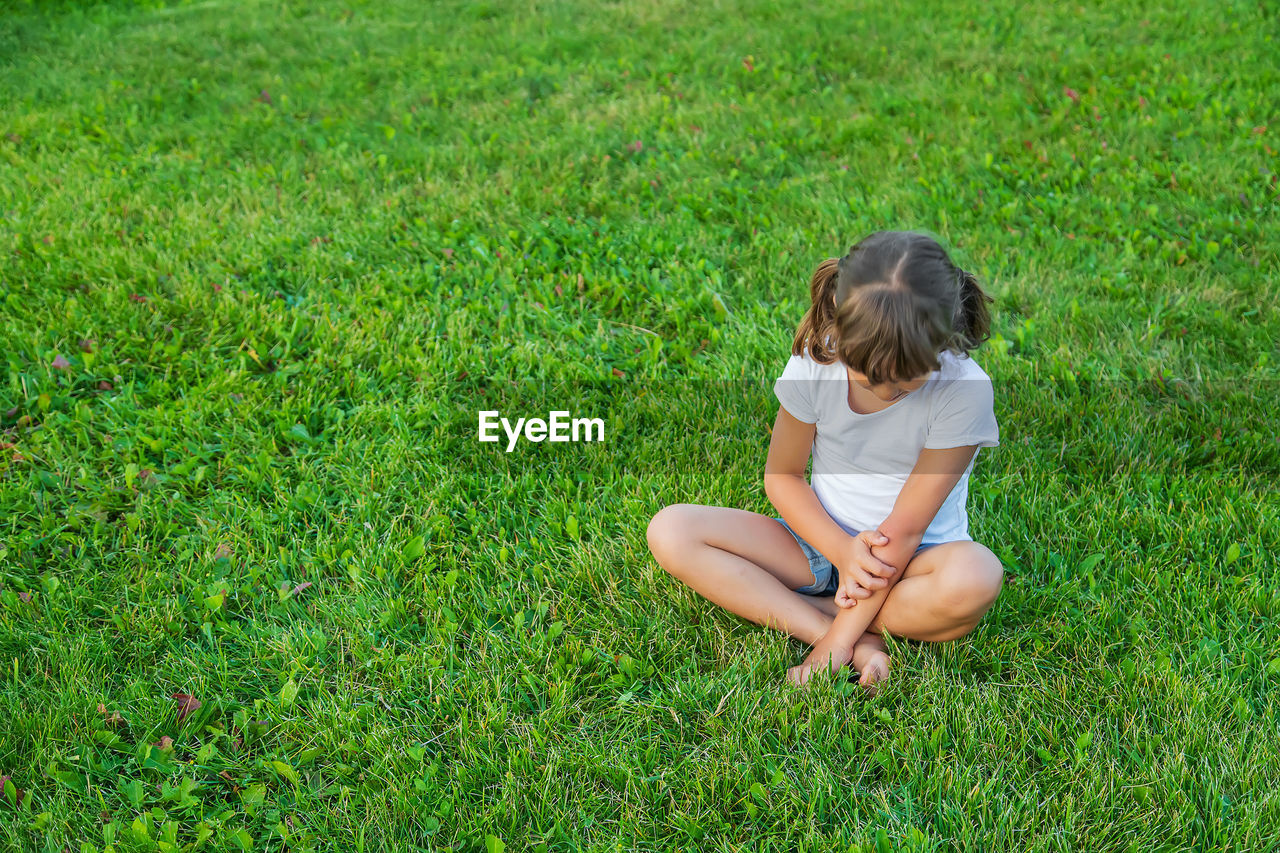 side view of girl playing with ball on grassy field