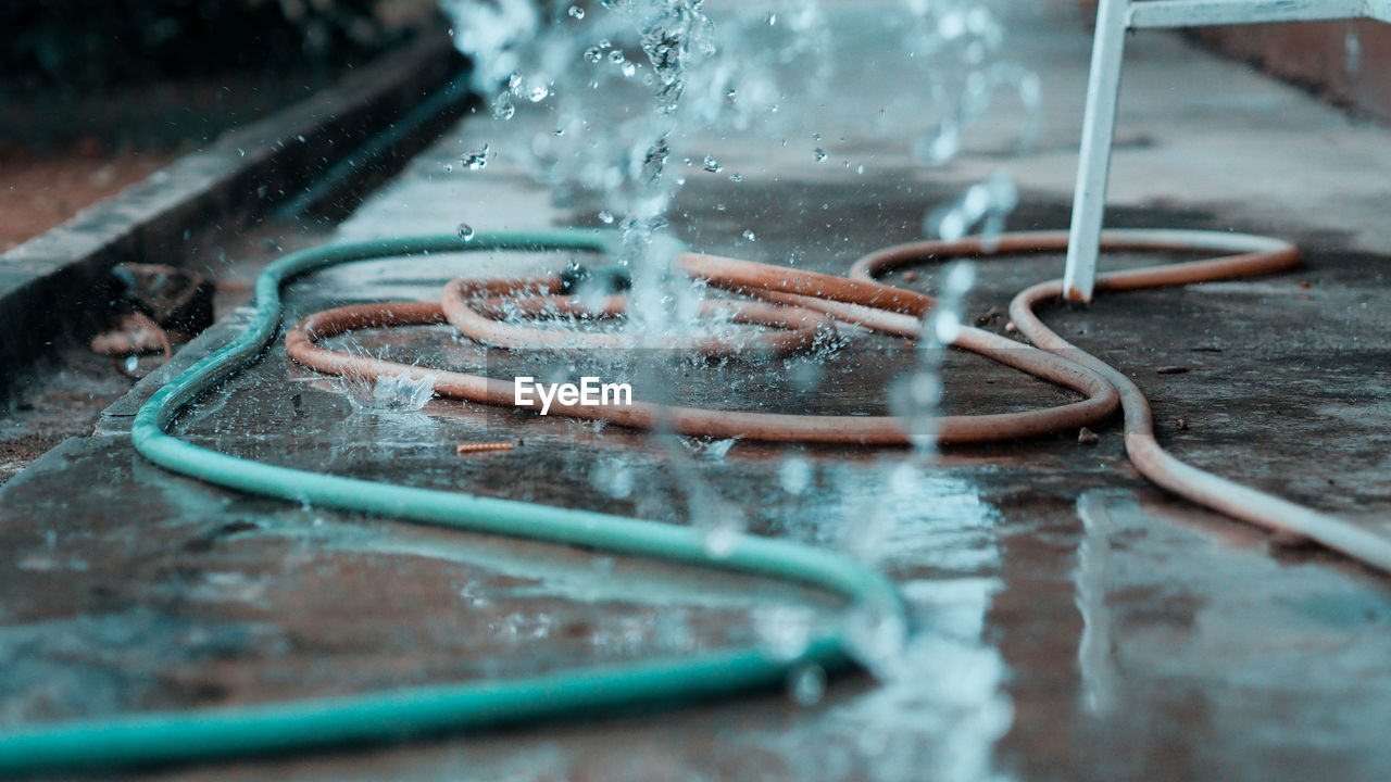 CLOSE-UP OF WATER PIPE ON METAL FLOOR