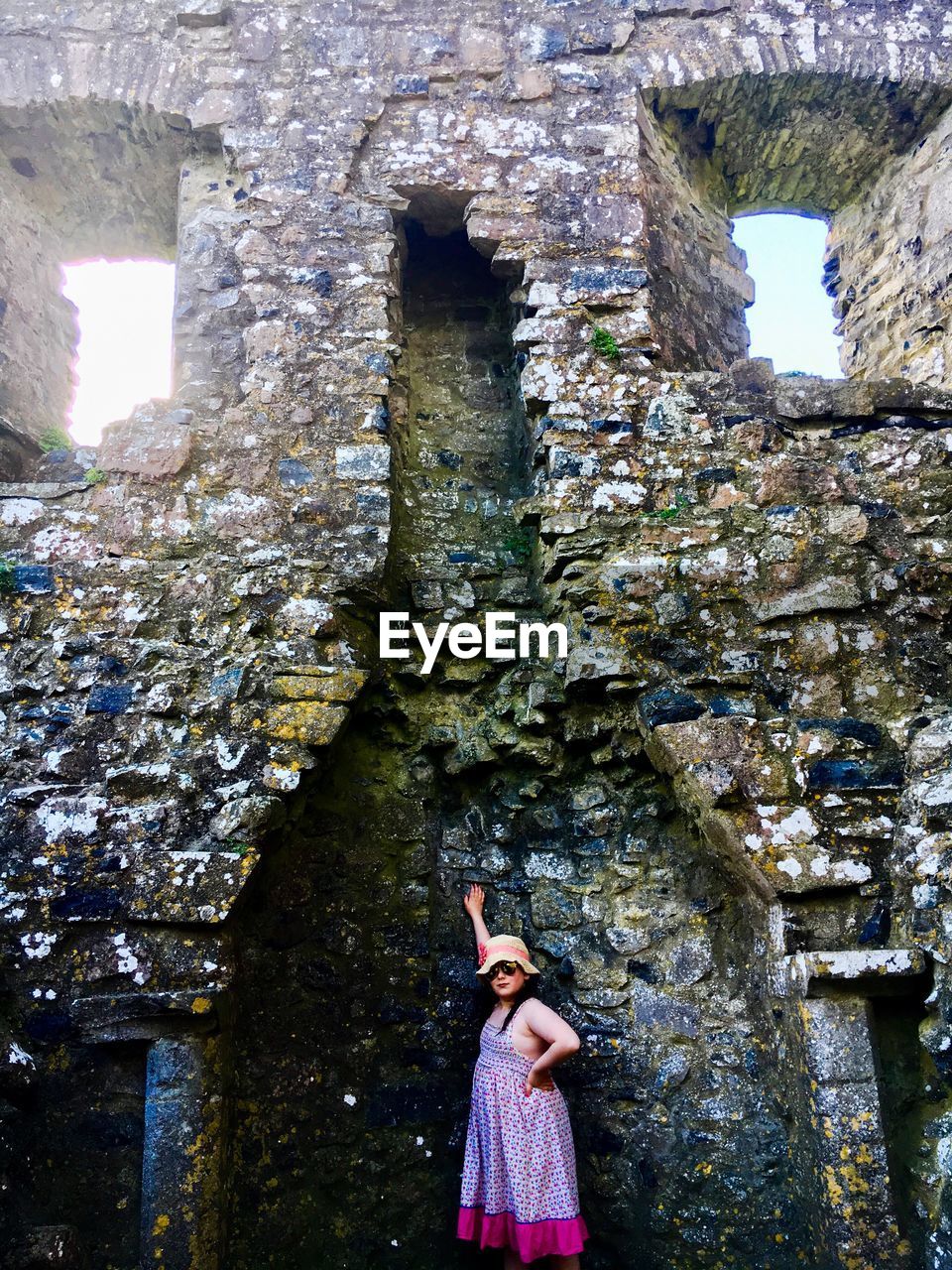 Side view of girl standing in damaged chimney