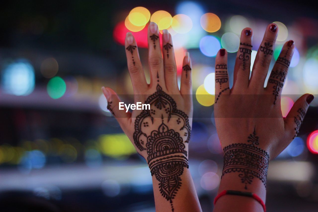 Cropped hands of women with henna tattoo