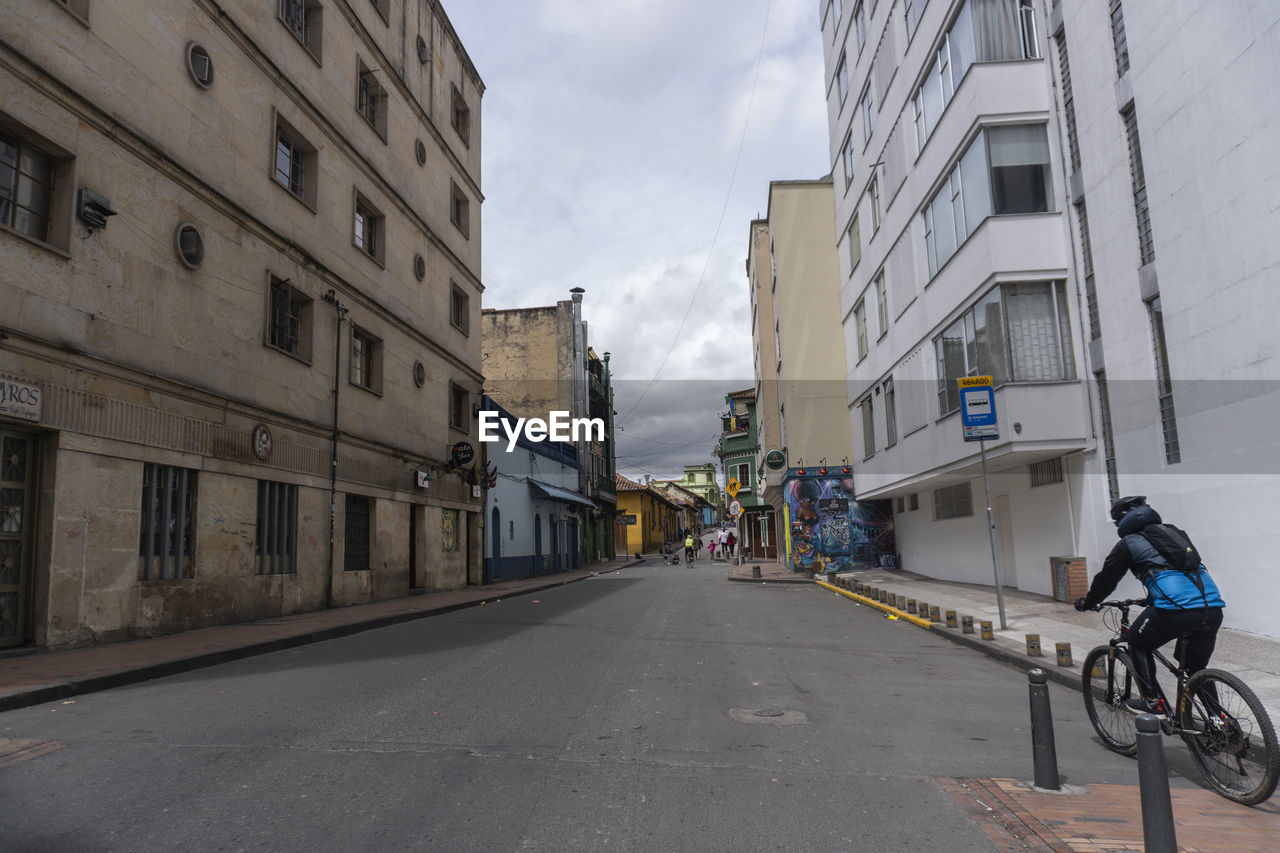 BICYCLE ON ROAD BY BUILDINGS IN CITY