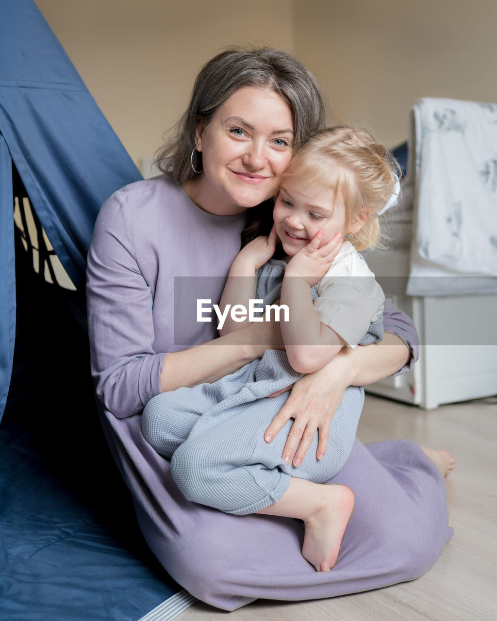 Happy mother and baby sitting on floor