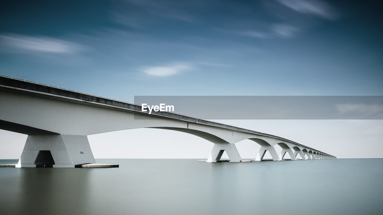 Low angle view of bridge over river against sky