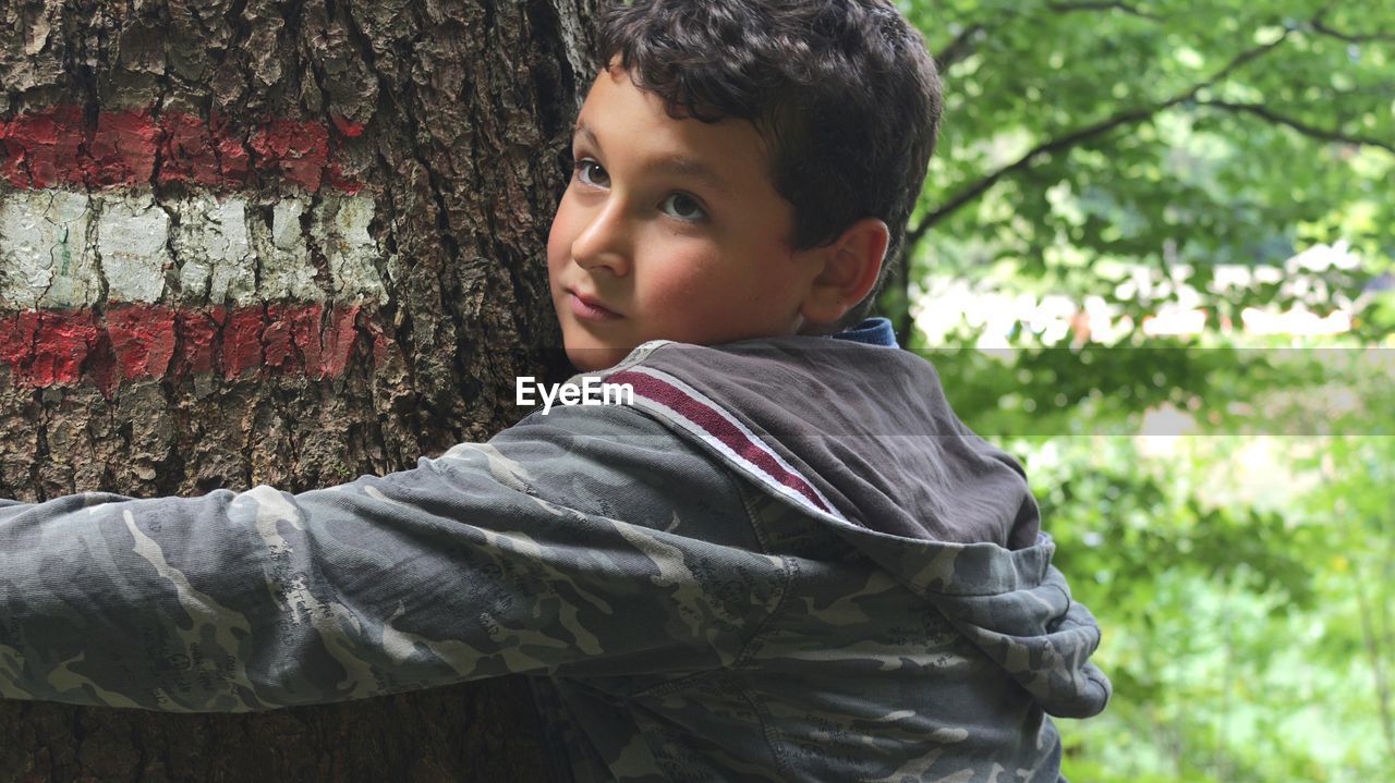 Portrait of boy in tree trunk