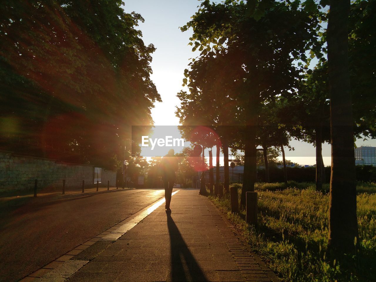 Person walking on footpath at sunset