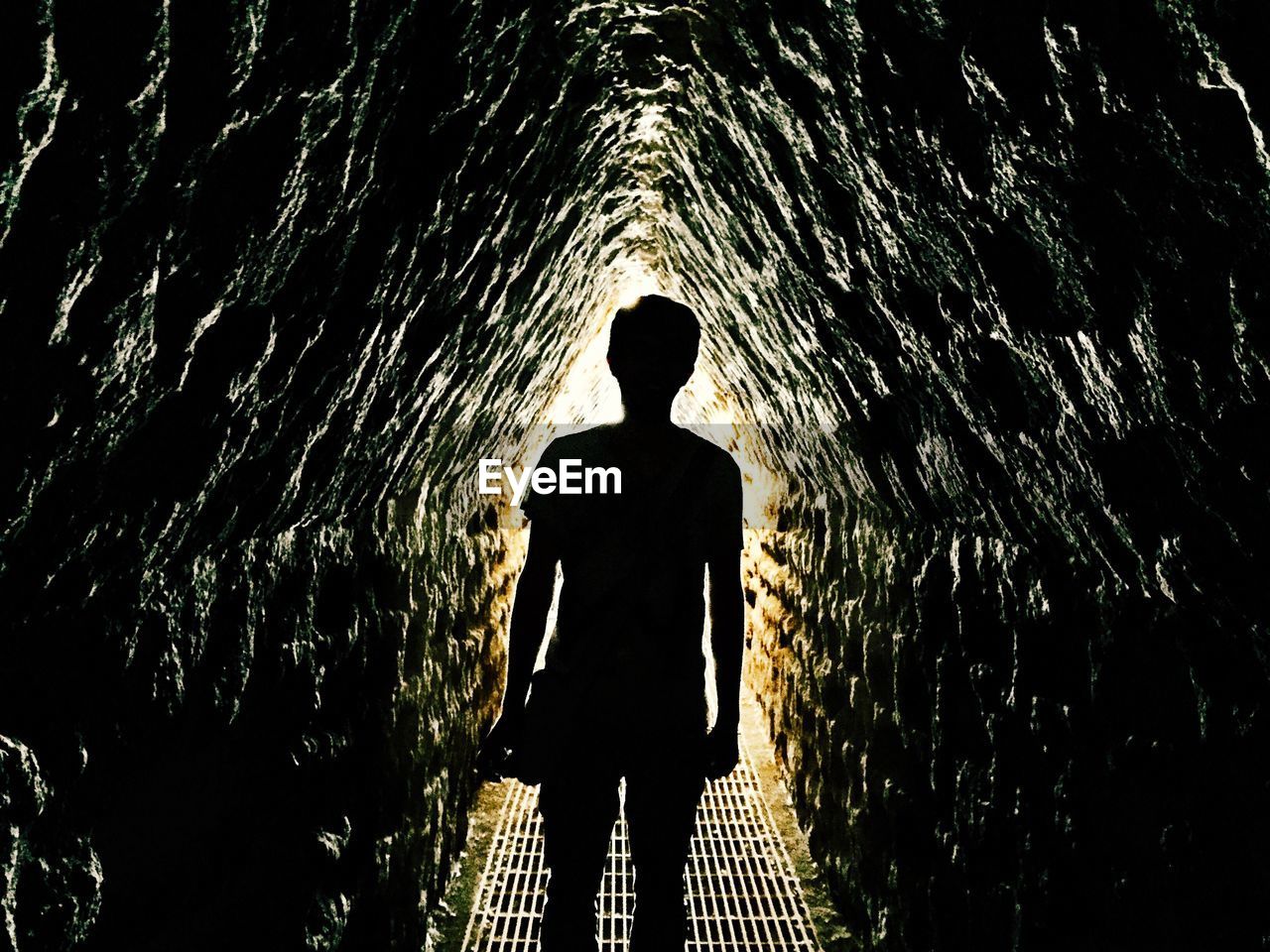 Rear view of man standing in tunnel