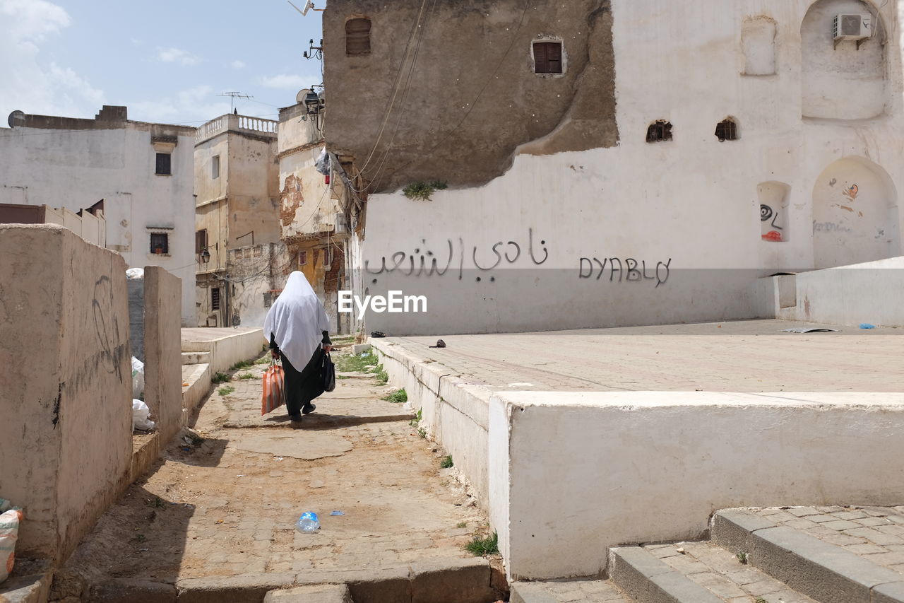 Algerian woman walking in an old part of algiers 