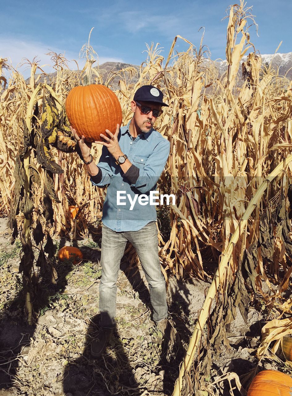 FULL LENGTH OF SENIOR MAN STANDING IN FIELD