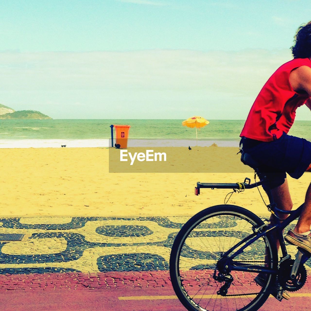 MAN RIDING BICYCLE ON BEACH