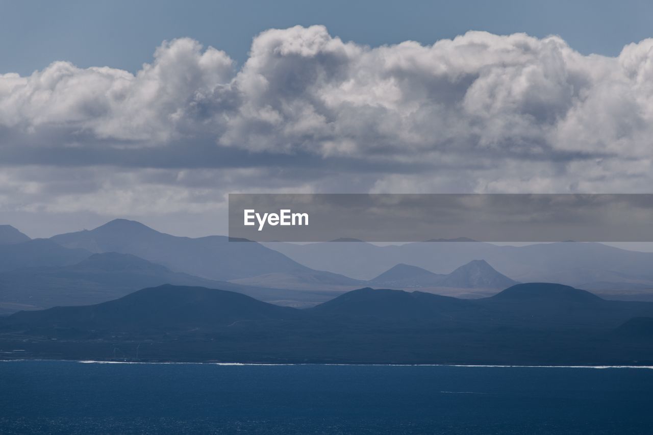 SCENIC VIEW OF SEA AND MOUNTAIN AGAINST SKY