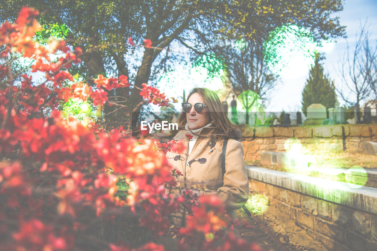 Woman standing by flowers at cemetery