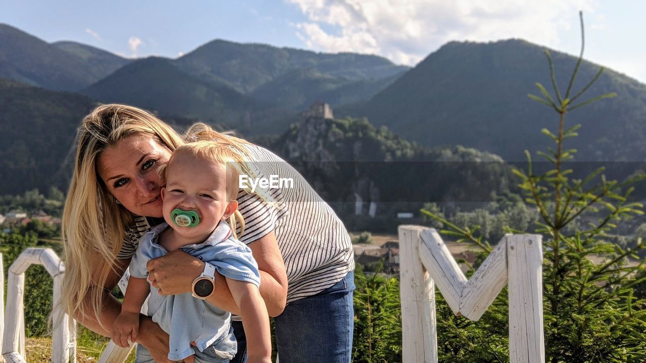 Portrait of smiling mother with son against mountain