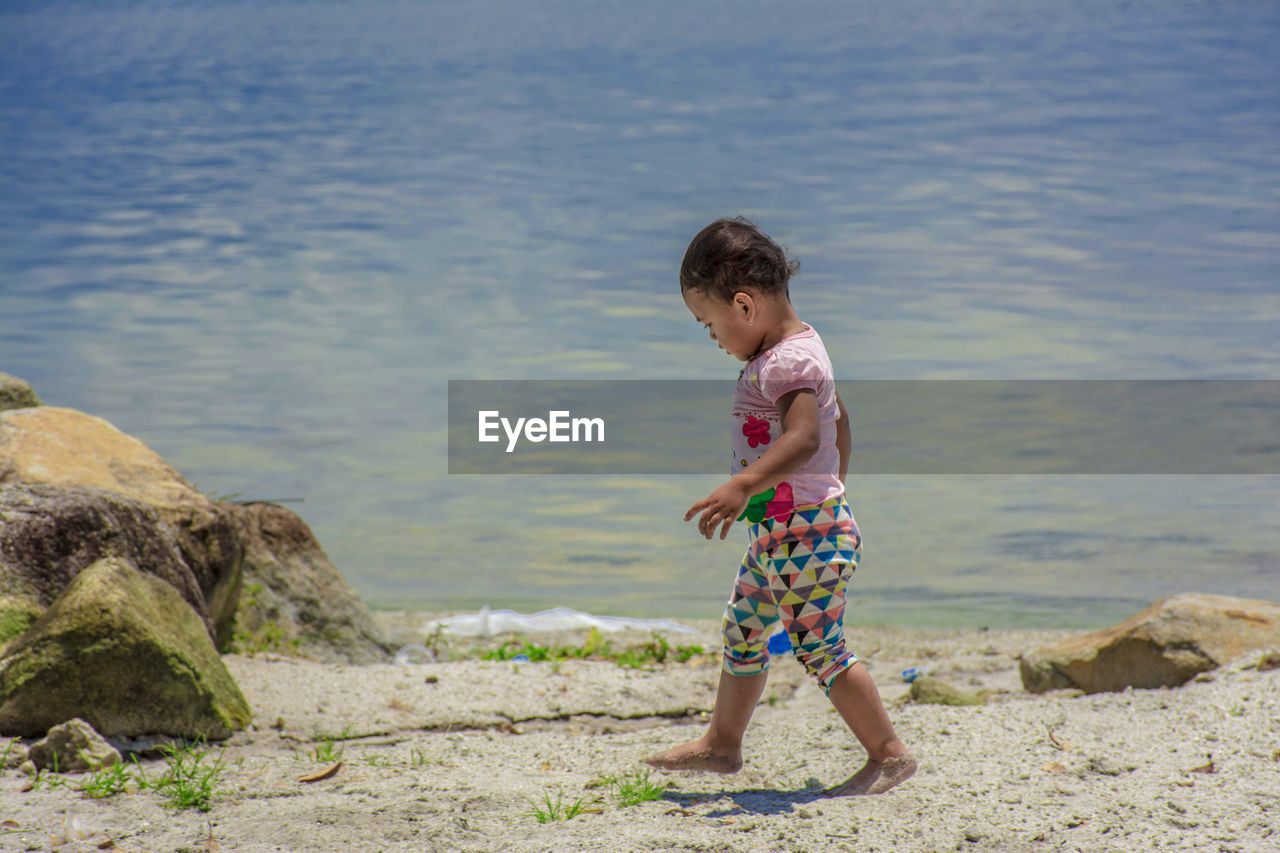 A child walks on the edge of lake toba