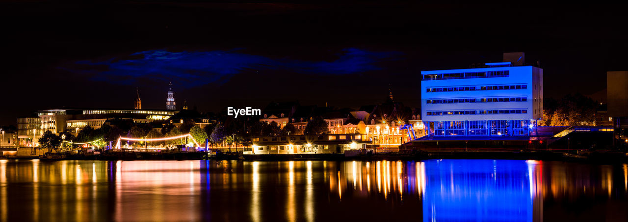 REFLECTION OF ILLUMINATED BUILDINGS IN CALM SEA