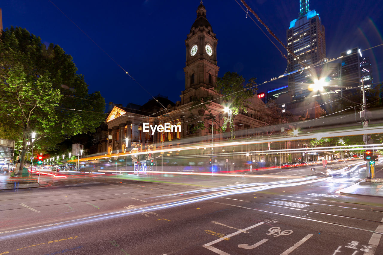 Light trails outside melbourne town hall on city street at night