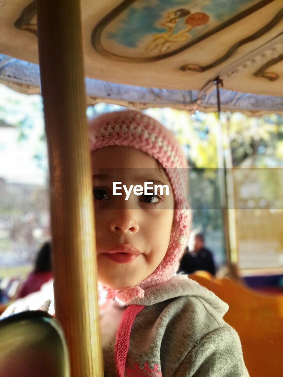 Close-up of girl on carousel at amusement park