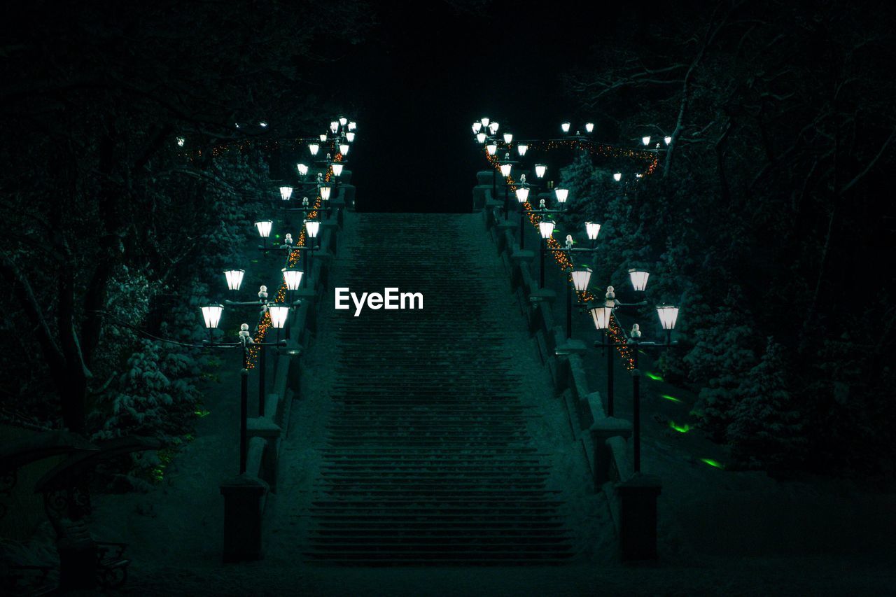 High angle view of steps amidst illuminated steps at night