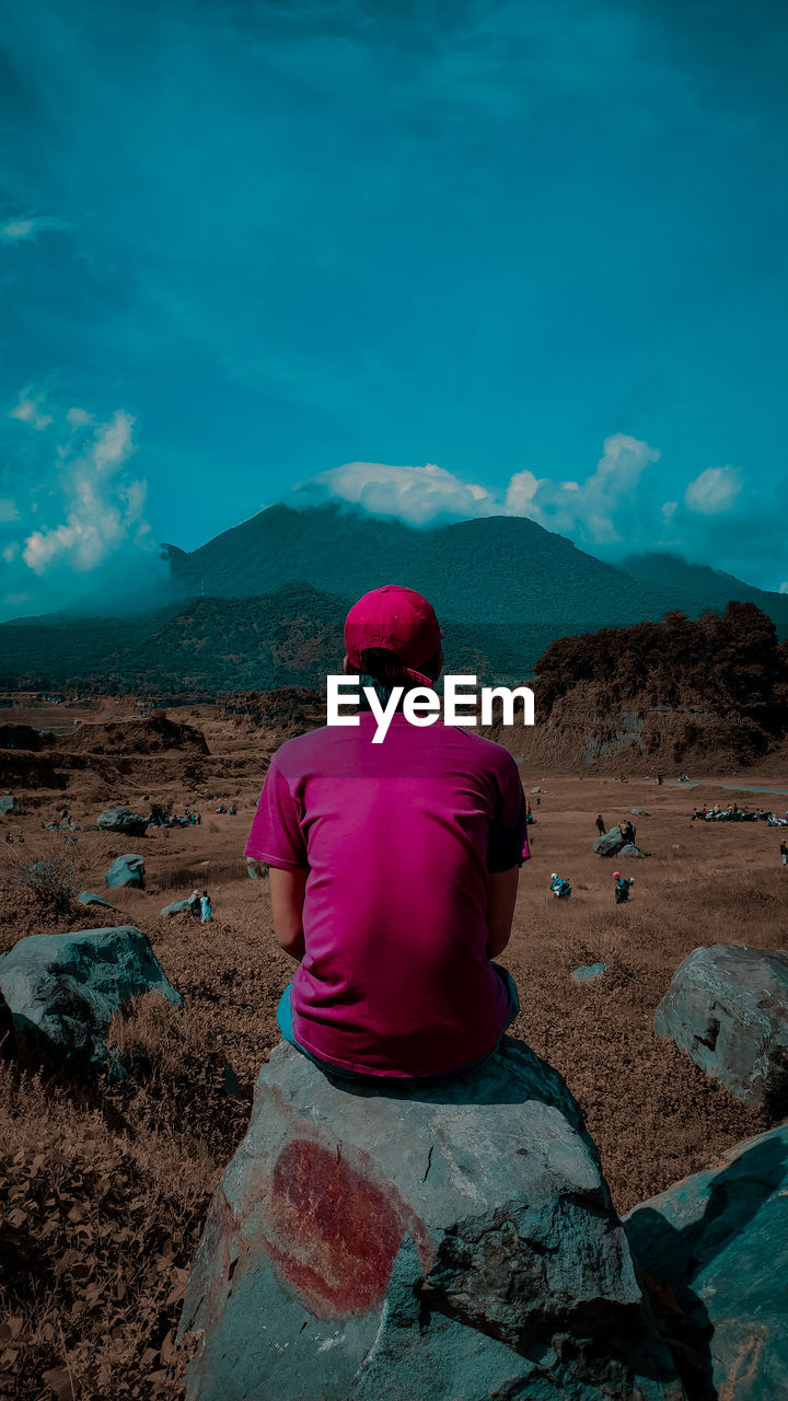 Rear view of man on landscape against sky