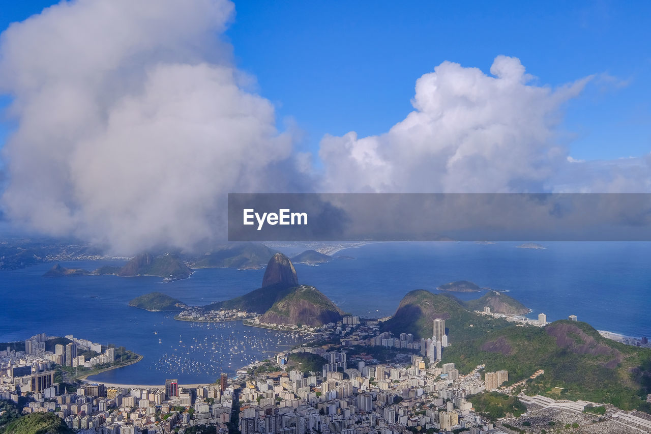 PANORAMIC VIEW OF TOWNSCAPE BY SEA AGAINST SKY