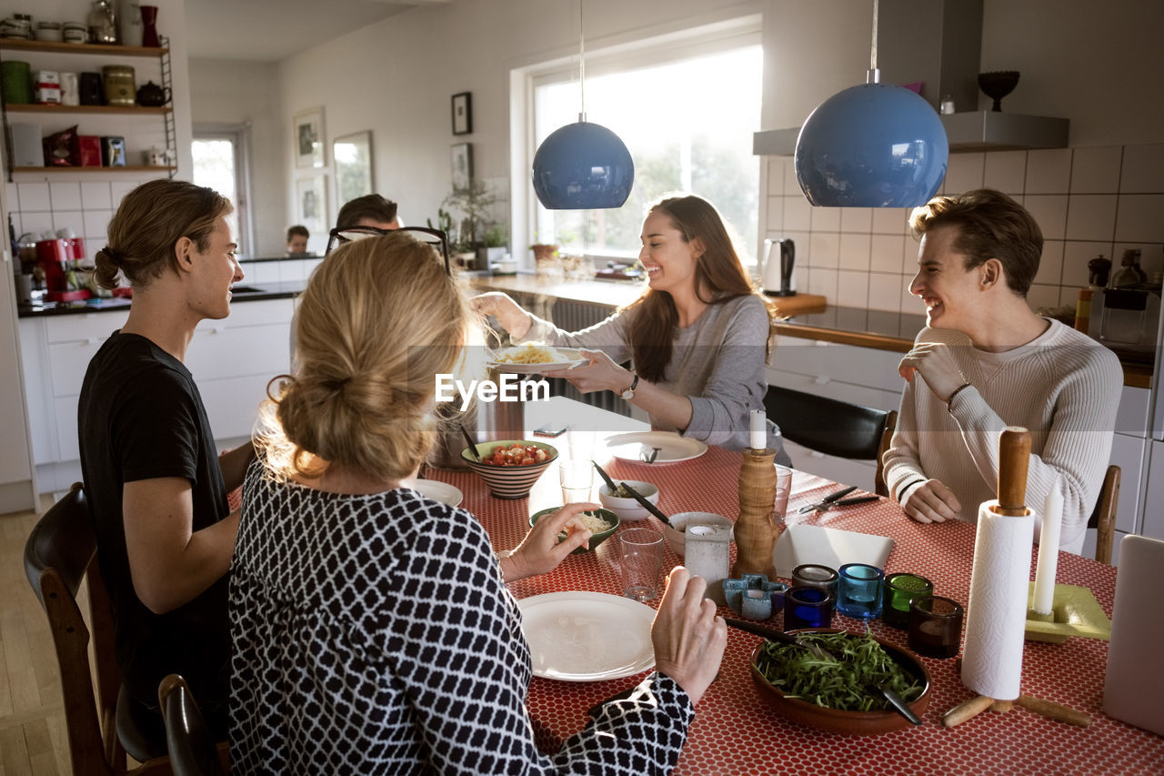 Woman serving food for family at dining table