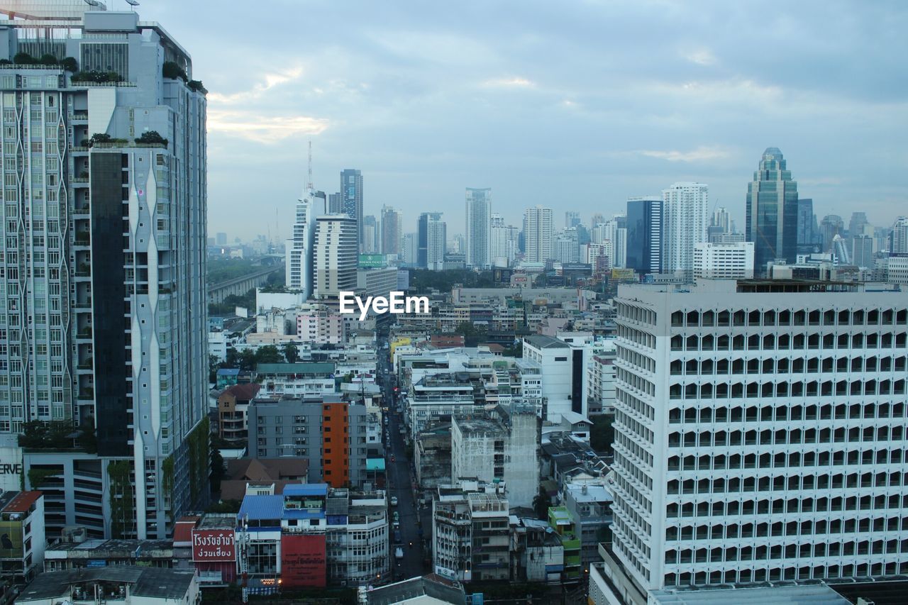 View of cityscape against cloudy sky