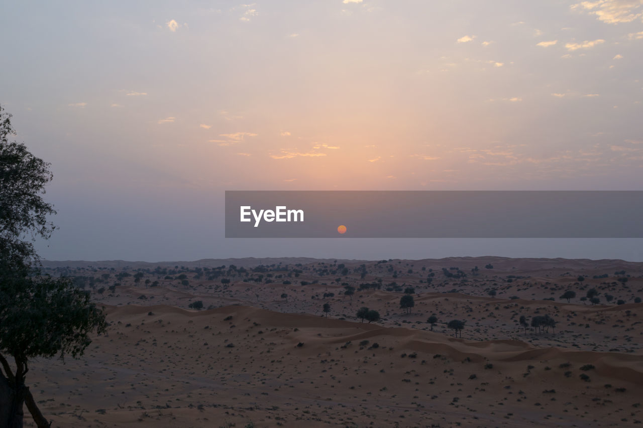 Scenic view of beach against sky during sunset