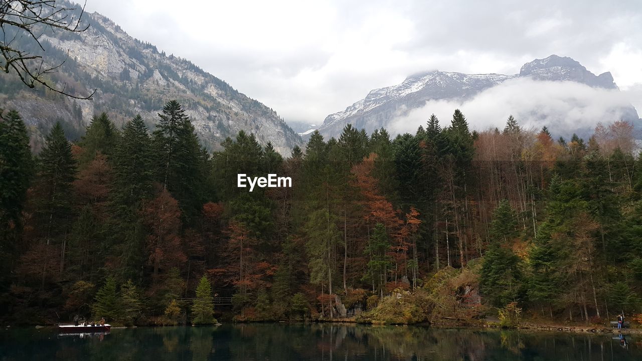 SCENIC VIEW OF MOUNTAINS AND LAKE AGAINST CLOUDY SKY