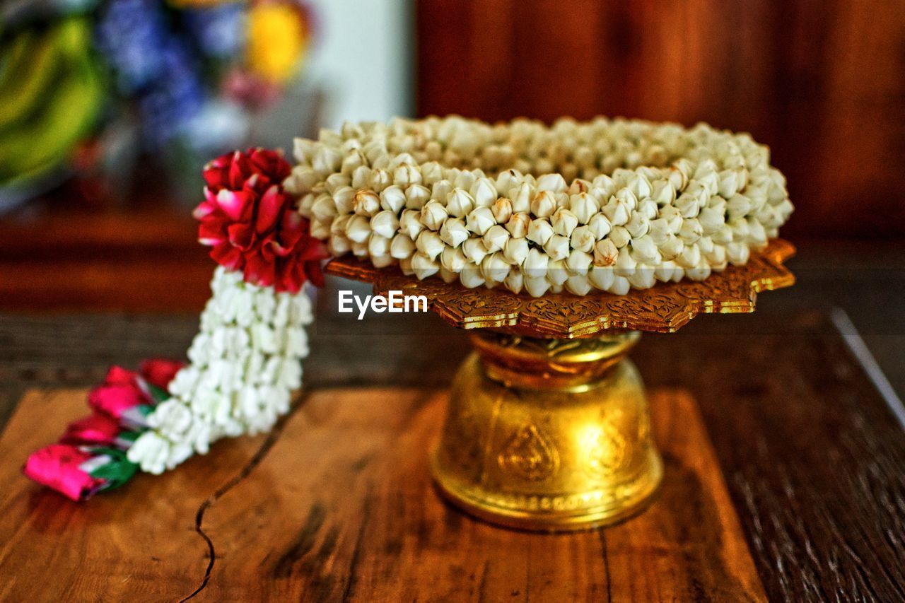 Close-up of floral garland on golden stand