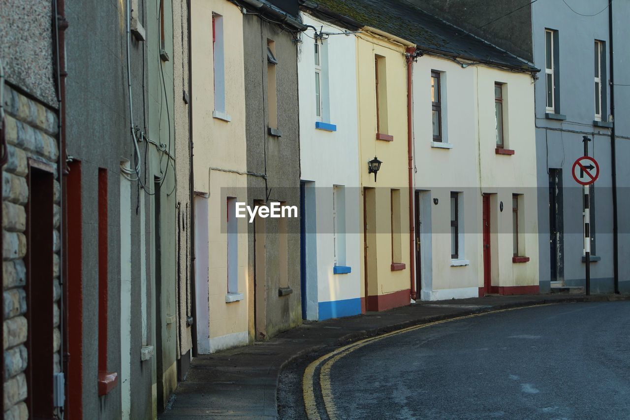 Empty road by buildings in city