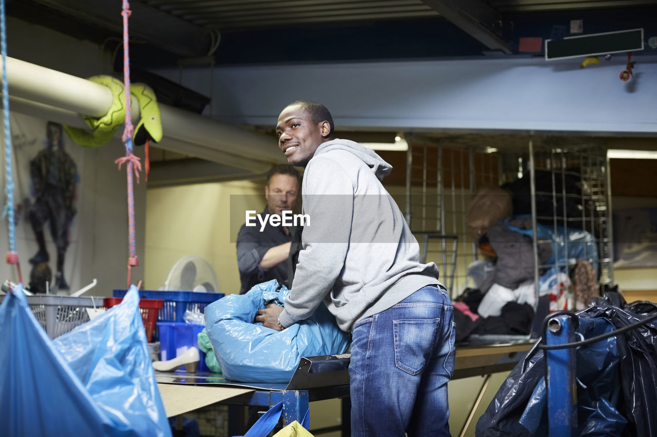 Male volunteers working at workbench in warehouse