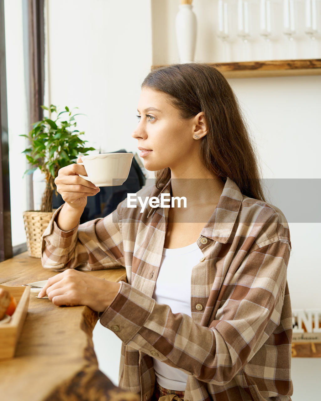 Young woman looking away while sitting at home