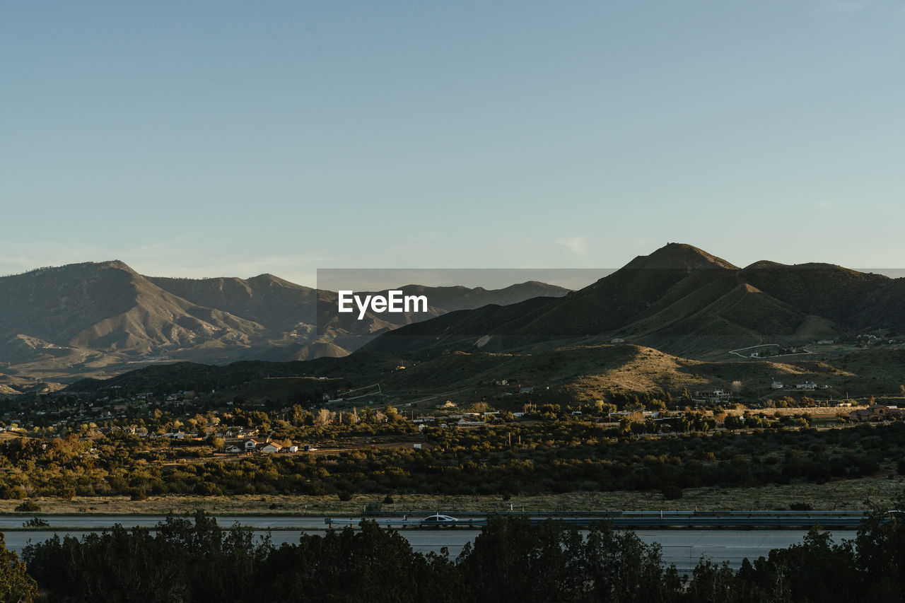 LAKE BY MOUNTAINS AGAINST CLEAR SKY