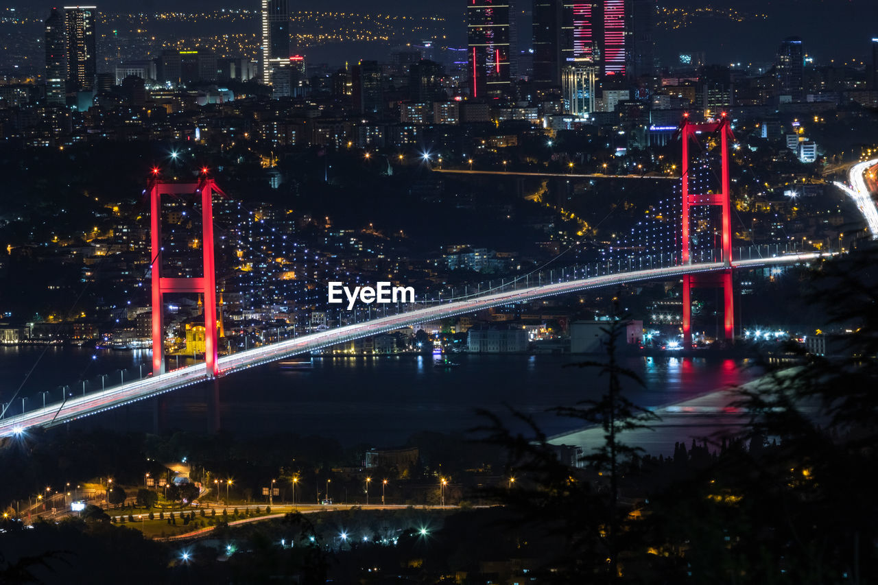 High angle view of illuminated bridge and buildings at night