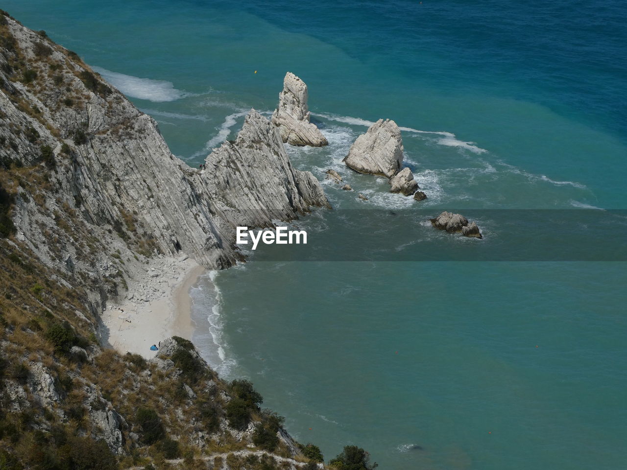 HIGH ANGLE VIEW OF ROCKS ON SEA