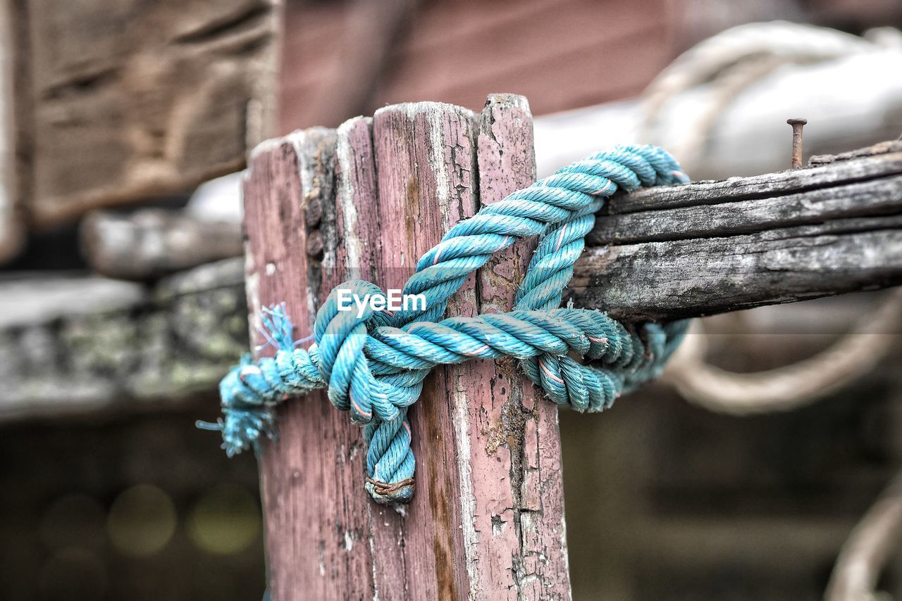 Close-up of rope tied on weathered wood