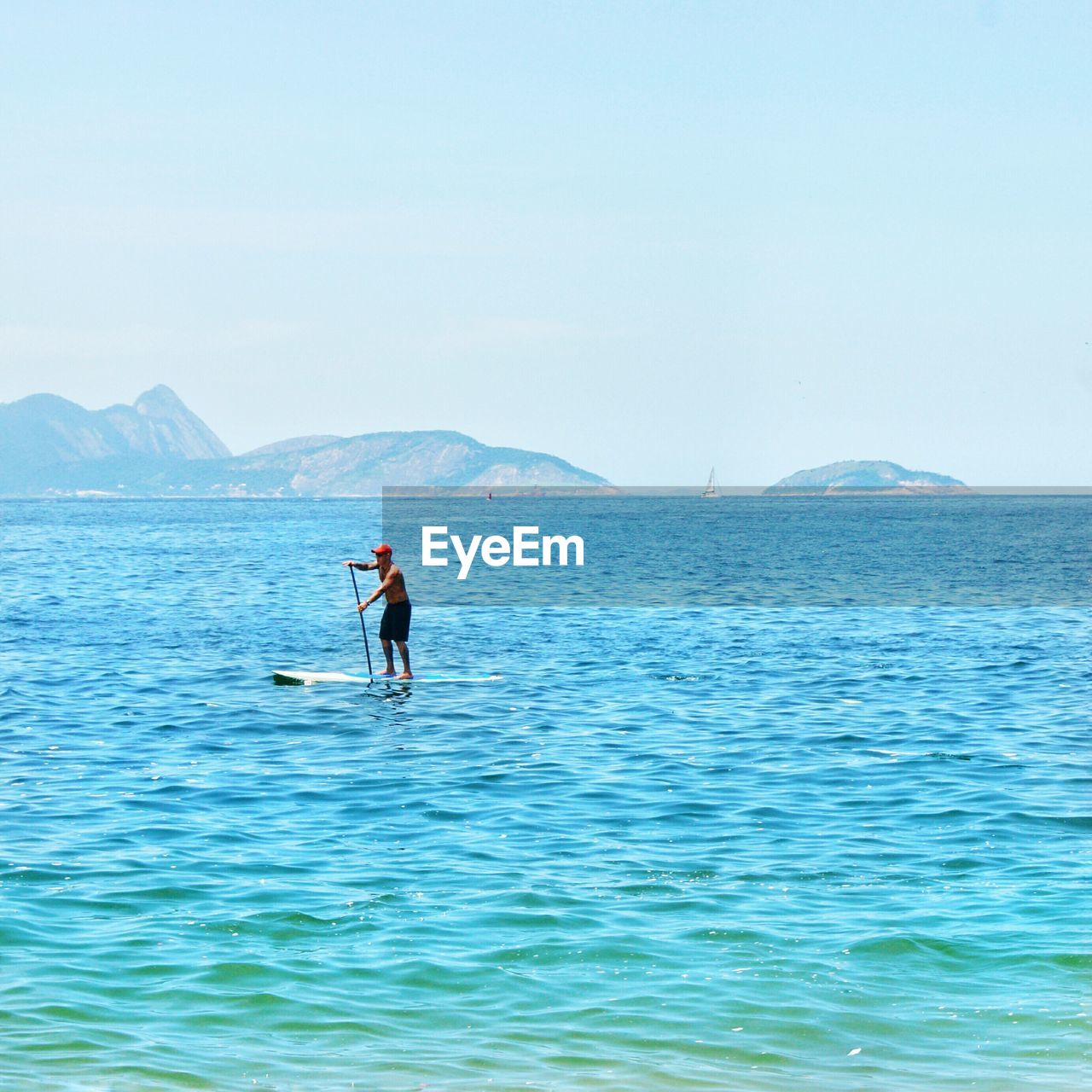 MAN SURFING IN SEA AGAINST SKY