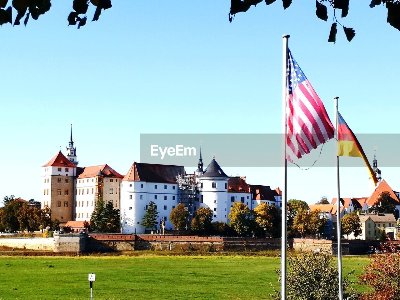 Flag by building against clear blue sky