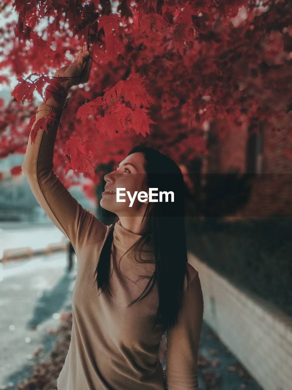 Woman standing by tree during autumn