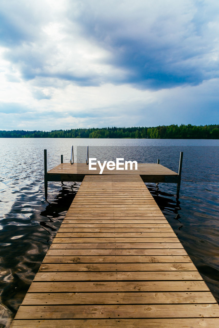 Jetty in lake against sky