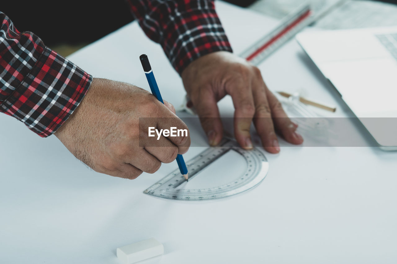 MIDSECTION OF MAN WORKING ON PAPER