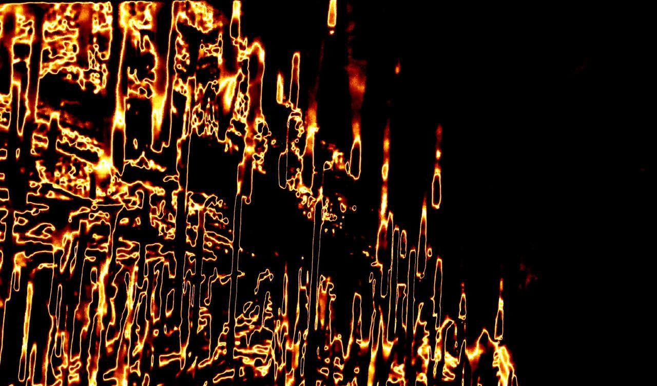 CLOSE-UP OF ILLUMINATED FIRE IN BLACK BACKGROUND