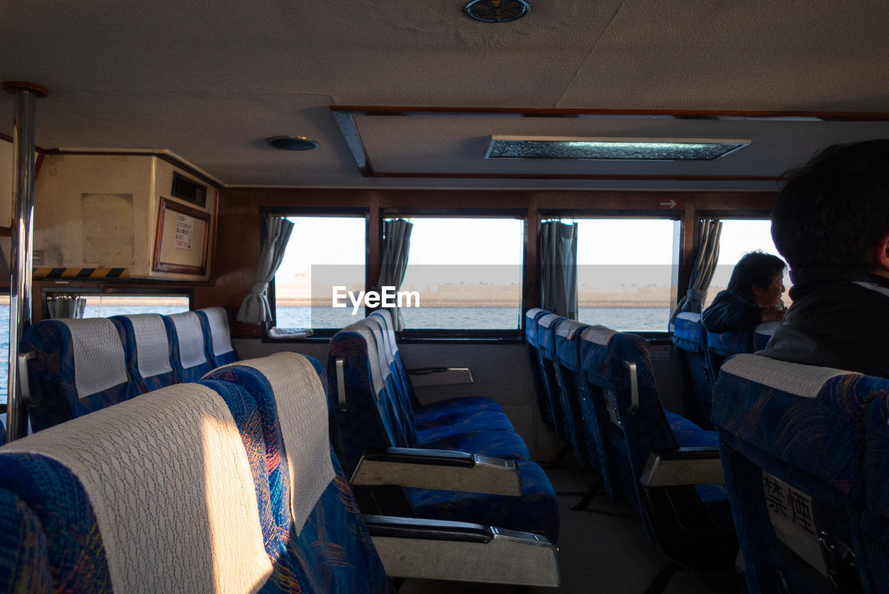 transportation, vehicle, mode of transportation, vehicle interior, passenger, travel, transport, sitting, men, adult, seat, window, vehicle seat, rear view, indoors, minibus, car, airplane, land vehicle, day, bus, journey, air vehicle, control, nature
