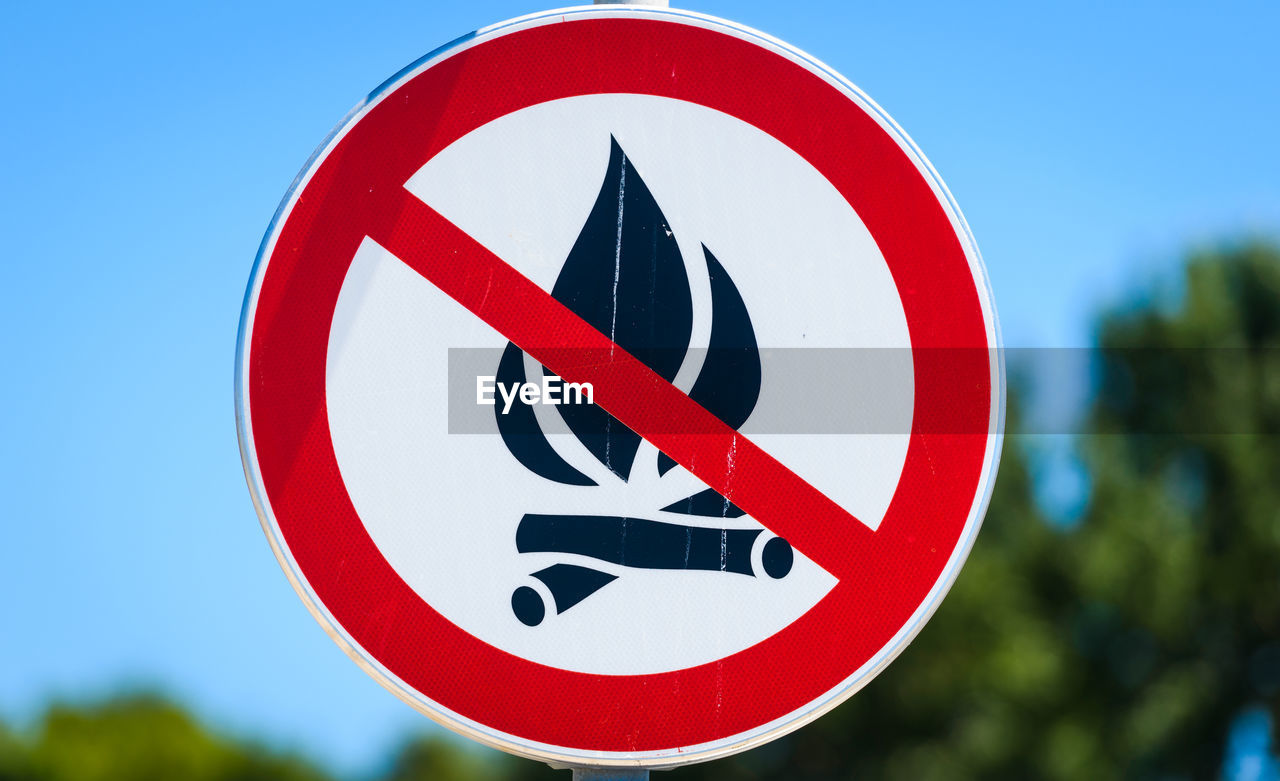 CLOSE-UP OF ROAD SIGN AGAINST BLUE SKY