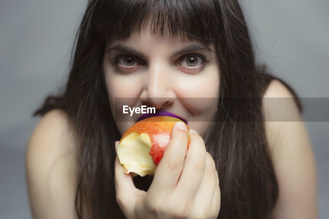 Portrait of young woman eating apple